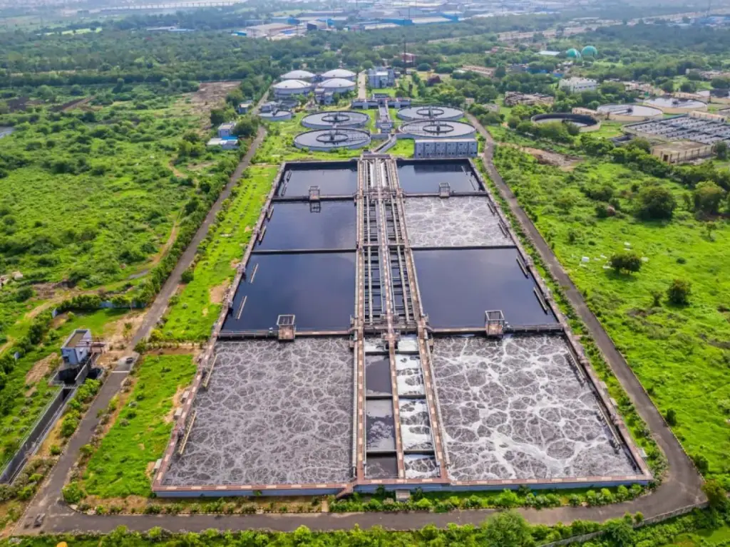 Aerial view of a large sewage treatment plant with aeration tanks and clarifiers